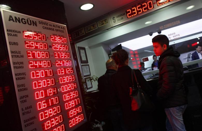 People check currency exchange rates at an currency exchange office in Istanbul December 16, 2014. REUTERS/Murad Sezer